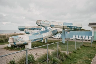 Vue grand angle du parc aquatique du Touquet avec toboggans en béton vieilli et ambiance nostalgique côtière