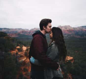 man kissing woman's forehead