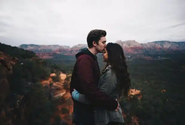 man kissing woman's forehead